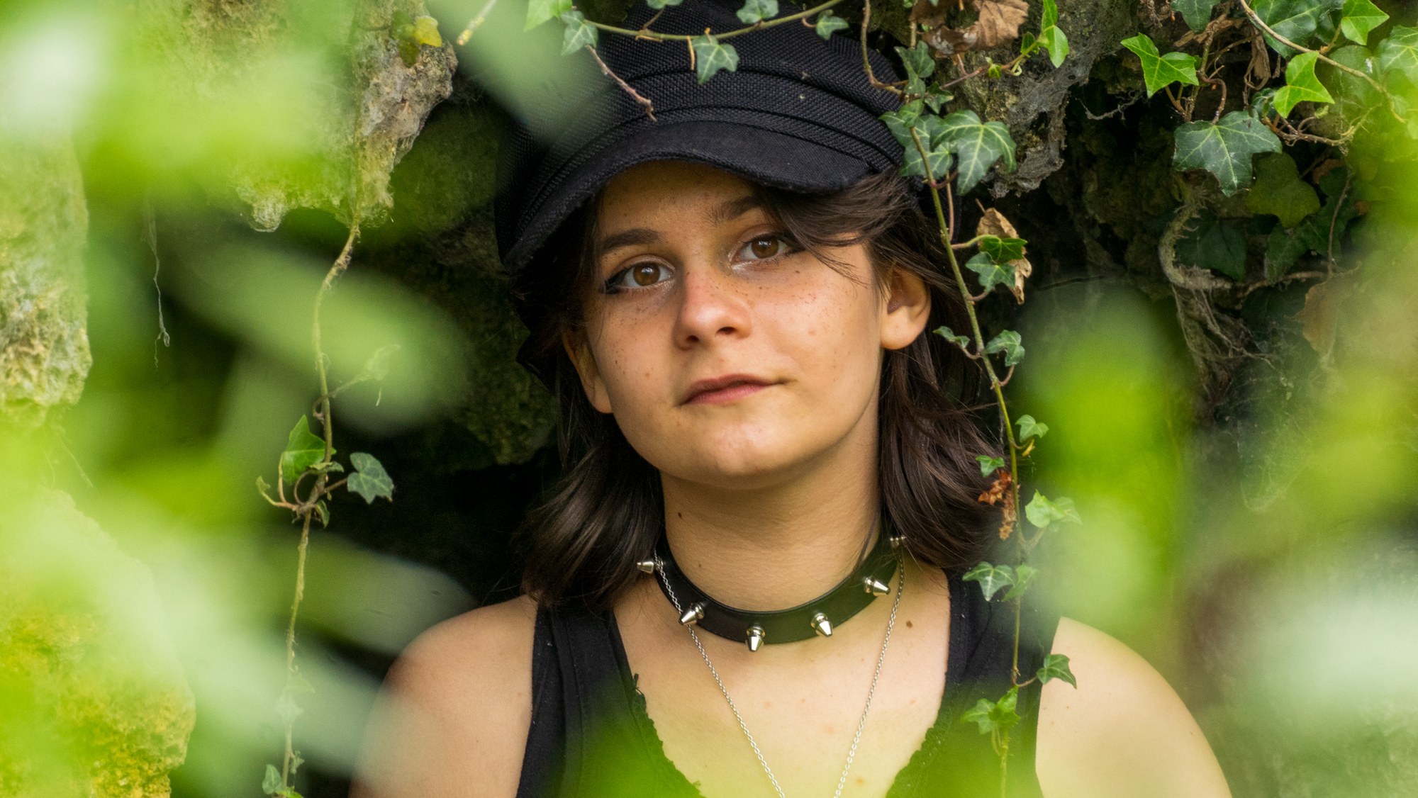 Portrait de Lizie entourée de feuillage.
