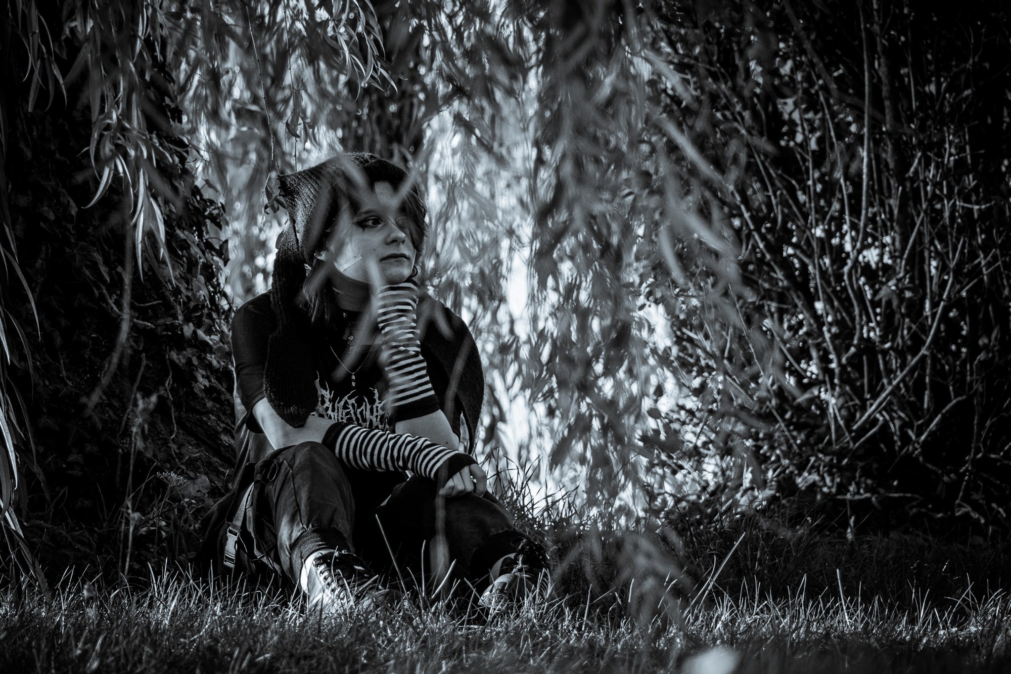 Portrait en noir et blanc de Lizie sous les branches d’un arbre.