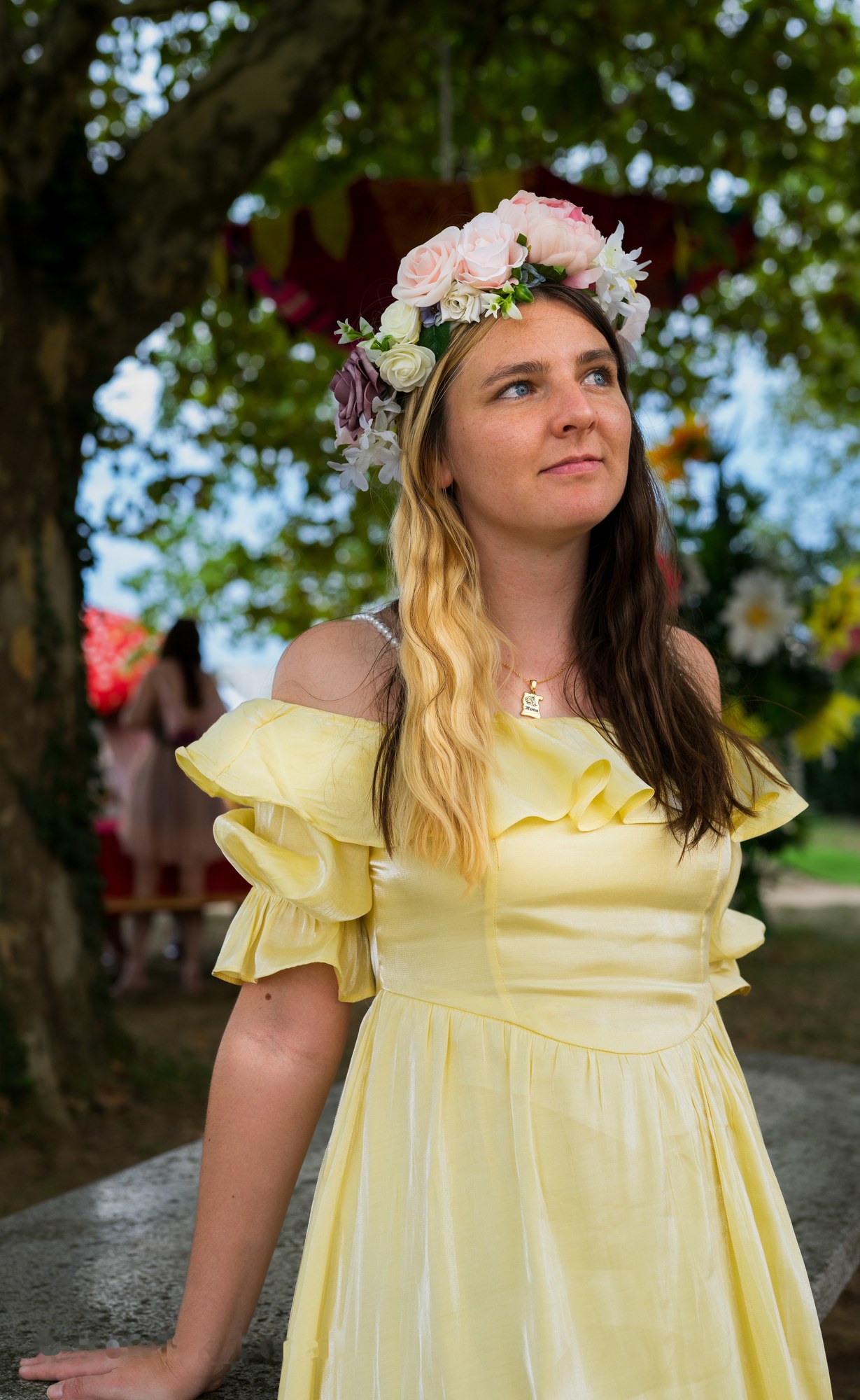 Portrait en extérieur avec une robe jaune et une couronne de fleurs.