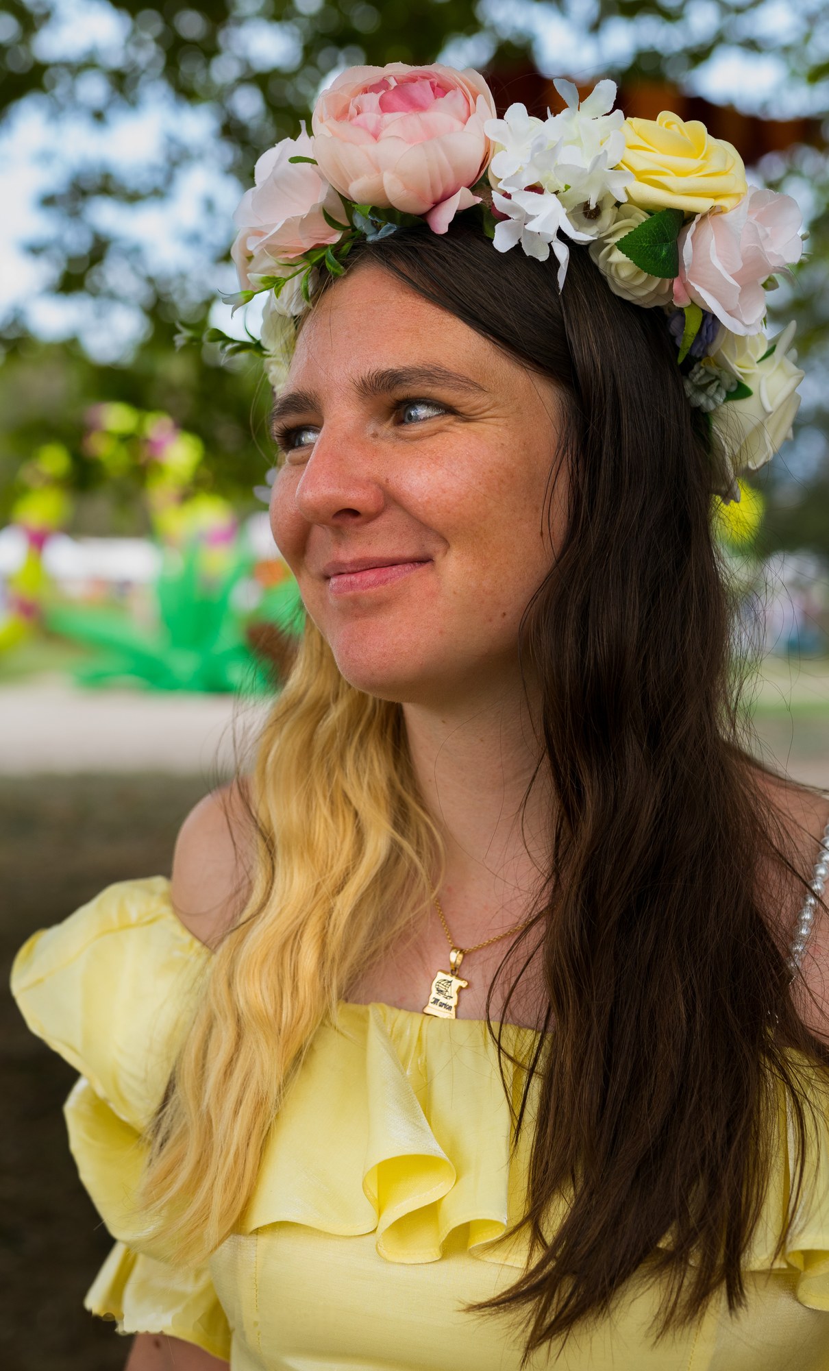 Portrait souriant avec une couronne de fleurs.